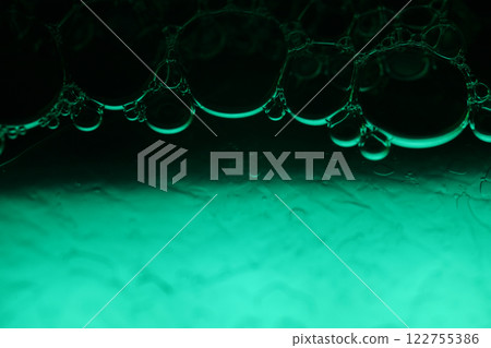 Green liquid surface, fantastic bubbles connections, fluid movement, dark fantastic background, transparent forms, black and green 122755386