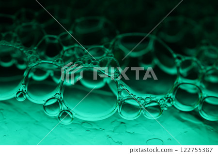 Green liquid surface, fantastic bubbles connections, fluid movement, dark fantastic background, transparent forms, black and green 122755387