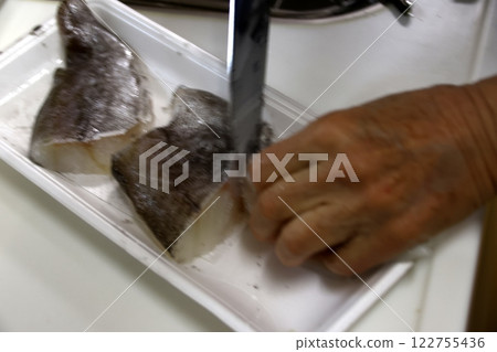 A housewife cutting up a cod fish A housewife cutting up a cod fish 122755436