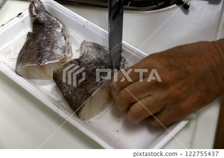 A housewife cutting up a cod fish A housewife cutting up a cod fish 122755437