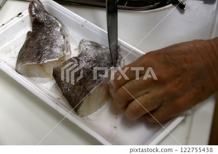 A housewife cutting up a cod fish A housewife cutting up a cod fish 122755438