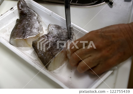 A housewife cutting up a cod fish 122755439