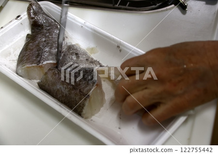 A housewife cutting up a cod fish A housewife cutting up a cod fish 122755442