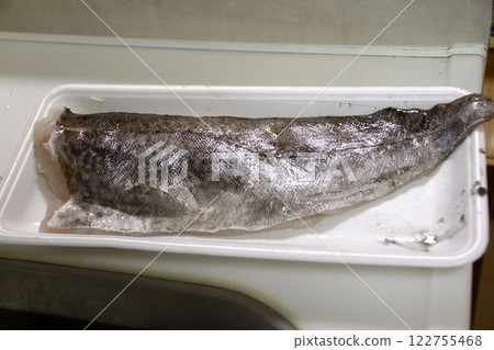 A housewife cutting up a cod fish 122755468