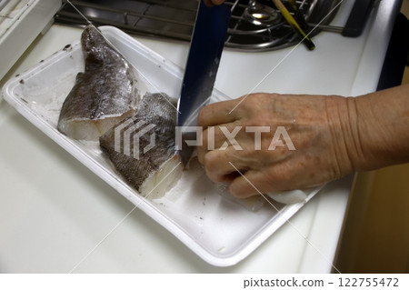 A housewife cutting up a cod fish A housewife cutting up a cod fish 122755472