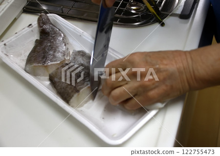 A housewife cutting up a cod fish A housewife cutting up a cod fish 122755473