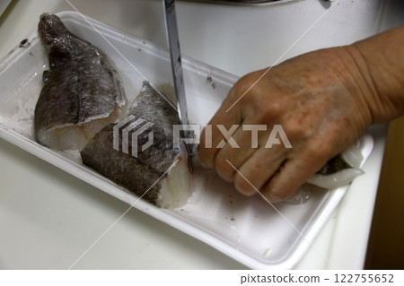 A housewife cutting up a cod fish A housewife cutting up a cod fish 122755652