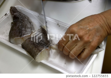 A housewife cutting up a cod fish A housewife cutting up a cod fish 122755655
