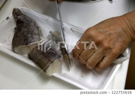 A housewife cutting up a cod fish A housewife cutting up a cod fish 122755656
