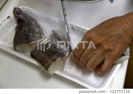 A housewife cutting up a cod fish 122755716