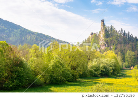medieval orava castle of slovakia, europe. travel landmark. high tower above landscape with trees and meadow in spring. sunny day. nature in blossom 122756186
