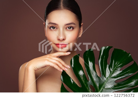 Close up woman face with green exotic leaf 122756372