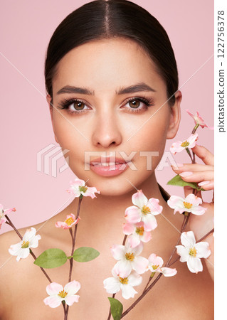 Beautiful young woman with a cherry blossom branch Beautiful young woman with a cherry blossom branch 122756378