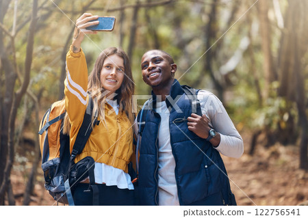 Hiking, diversity and couple taking a selfie with a phone while they smile, happy and travel in nature forest. Trekking, love and romance on adventure journey date with trees, earth and leaf growth Hiking, diversity and couple taking a selfie with a phone while they smile, happy and travel in nature forest. Trekking, love and romance on adventure journey date with trees, earth and leaf growth 122756541