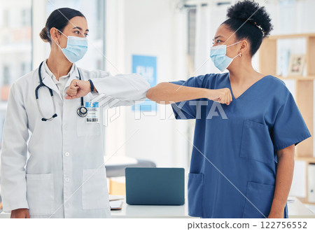 Woman doctor and nurse, in a hospital elbow greeting, in surgical mask during the covid pandemic. Teamwork, healthcare worker and medical professional with protection from virus during consultation Woman doctor and nurse, in a hospital elbow greeting, in surgical mask during the covid pandemic. Teamwork, healthcare worker and medical professional with protection from virus during consultation 122756552