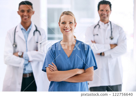 Portrait of medical doctors with crossed arms with a stethoscope standing in the hospital hallway. Happy healthcare workers after clinic trial, surgery or consultation success at a medicare center. Portrait of medical doctors with crossed arms with a stethoscope standing in the hospital hallway. Happy healthcare workers after clinic trial, surgery or consultation success at a medicare center. 122756640