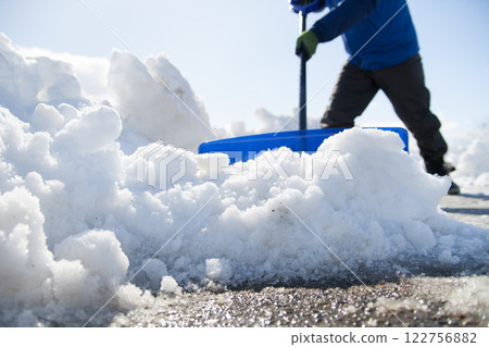 Man clearing snow from the sidewalk Man clearing snow from the sidewalk 122756882