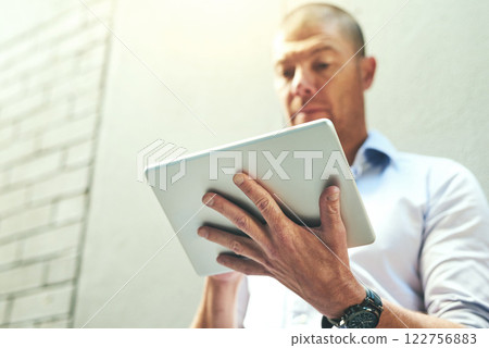 Businessman working on a tablet, reading quick email message online or checking company SEO website data while waiting outside. Mature corporate professional browsing internet on wireless technology Businessman working on a tablet, reading quick email message online or checking company SEO website data while waiting outside. Mature corporate professional browsing internet on wireless technology 122756883
