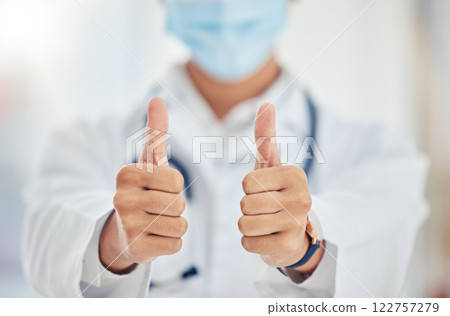 Thumbs up doctor hand sign for covid surgery success, support and yes in a hospital. Medical and healthcare worker showing thank you, agreement or goal completion hands gesture in a health clinic 122757279