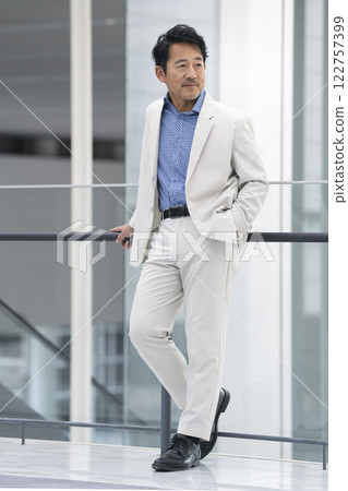 A man in his mid-50s wearing a white suit 122757399