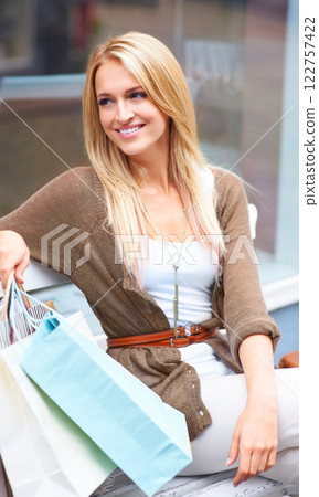 Shopping, fashion and retail, a woman with a smile, resting outside a mall. Relax on a bench, a happy customer after discount sale at the shopping mall. City lady with designer boutique shopping bags Shopping, fashion and retail, a woman with a smile, resting outside a mall. Relax on a bench, a happy customer after discount sale at the shopping mall. City lady with designer boutique shopping bags 122757422
