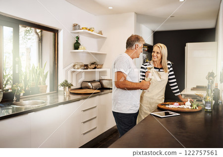 Mature couple cooking, drinking wine and preparing a meal together while bonding, having fun and talking in home kitchen. Smiling, happy and caring husband and wife making healthy food for date night Mature couple cooking, drinking wine and preparing a meal together while bonding, having fun and talking in home kitchen. Smiling, happy and caring husband and wife making healthy food for date night 122757561