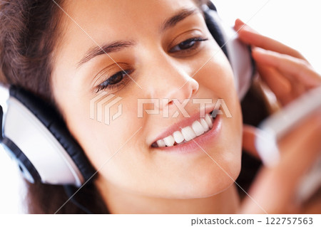 Happy girl, headphones and streaming music or podcast to relax in free time on the weekend. Beautiful and cute teen listening to audio playlist on smartphone with headset for study break. Happy girl, headphones and streaming music or podcast to relax in free time on the weekend. Beautiful and cute teen listening to audio playlist on smartphone with headset for study break. 122757563