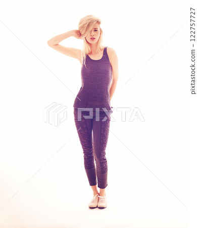 Fashion, model and beauty with a young woman posing in studio against a white background with creative lighting. Portrait of a sexy female looking sensual, elegant and confident in purple clothes Fashion, model and beauty with a young woman posing in studio against a white background with creative lighting. Portrait of a sexy female looking sensual, elegant and confident in purple clothes 122757727