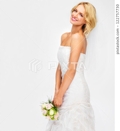 Portrait of bride wedding with flower bouquet and marriage dress on studio white background. Happy, smile and beauty of elegant young woman in bridal fashion getting married for celebration event 122757730