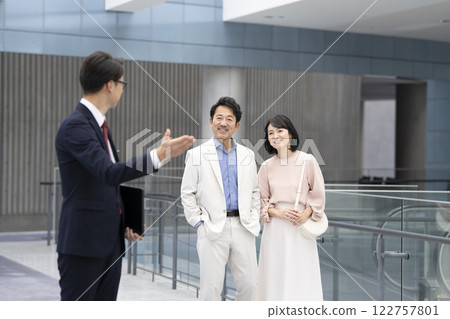 Salesman and a couple in their 50s viewing a property Salesman and a couple in their 50s viewing a property 122757801