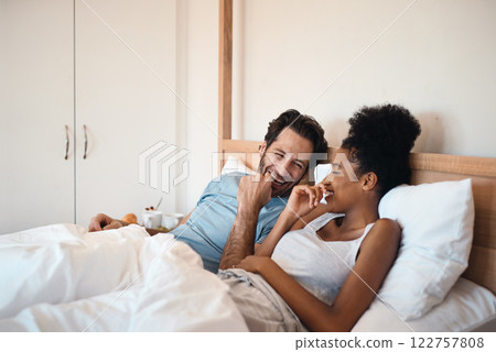 Happy, silly and goofy couple bonding in bed, sharing intimate relationship joke and moment. Young interracial husband and wife laughing, loving and enjoying lazy morning relaxing indoors together Happy, silly and goofy couple bonding in bed, sharing intimate relationship joke and moment. Young interracial husband and wife laughing, loving and enjoying lazy morning relaxing indoors together 122757808
