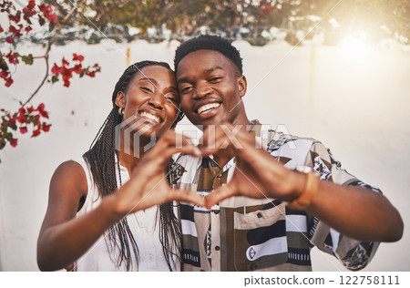 Happy couple heart love sign with their hands posing for a picture or photo while on vacation or holiday. Portrait of a loving and young African American lovers having fun together smiling in joy 122758111