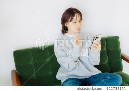 女人在沙發上使用智能手機 122758131