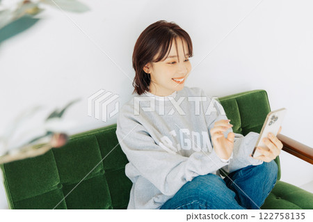女人在沙發上使用智能手機 122758135