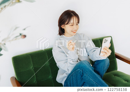 女人在沙發上使用智能手機 122758138