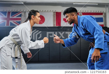 Karate, mma and fitness with a teacher and student learning, training and doing a workout for exercise, sport and health. Man and woman in fight, combat or self defense class in a gym studio 122758163