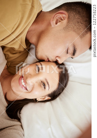 Happy, smiling and affectionate young couple in love taking a selfie together in the bed at home. Portrait of loving female taking a photo in happiness while her partner is sleeping during the day. 122758223