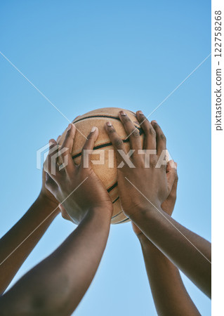 Teamwork, support and hands holding a basketball at the start of a league match or competition against a blue sky. Closeup of African American athletes or sportsmen playing and practicing with a ball Teamwork, support and hands holding a basketball at the start of a league match or competition against a blue sky. Closeup of African American athletes or sportsmen playing and practicing with a ball 122758268