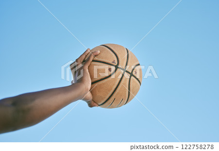 Basketball, active and sports man hand holding ball showing victory, power or athletic fitness from below with blue sky background. Player, black man or athlete arm practicing for professional league Basketball, active and sports man hand holding ball showing victory, power or athletic fitness from below with blue sky background. Player, black man or athlete arm practicing for professional league 122758278