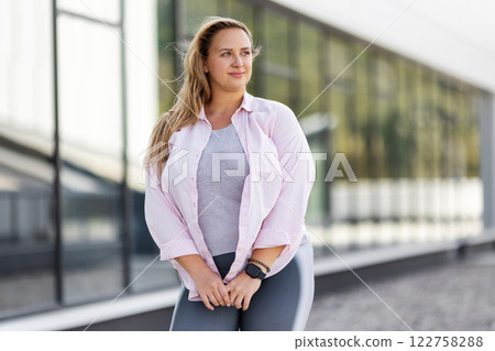 Happy Young Plus Size Woman outdoors on City Street at summer day Against Modern Building. Portrait Beautiful Curvy model in Sporty Outfit, Enjoying Active Lifestyle in Vibrant Urban, Body Positivity Happy Young Plus Size Woman outdoors on City Street at summer day Against Modern Building. Portrait Beautiful Curvy model in Sporty Outfit, Enjoying Active Lifestyle in Vibrant Urban, Body Positivity 122758288