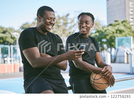 Male brothers on their phone spending time together, siblings or friends bonding as a family outdoors. Relaxing, smiling and taking breaks from African American men after playing basketball. Male brothers on their phone spending time together, siblings or friends bonding as a family outdoors. Relaxing, smiling and taking breaks from African American men after playing basketball. 122758291