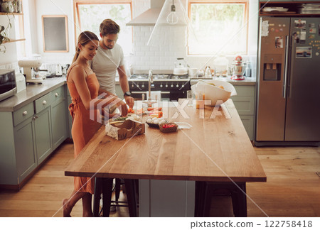 Couple cooking, home food or healthy meal for bonding, happy or fun man and woman in house kitchen together. Conversation, love or young people in modern interior with fresh salad vegetables on table Couple cooking, home food or healthy meal for bonding, happy or fun man and woman in house kitchen together. Conversation, love or young people in modern interior with fresh salad vegetables on table 122758418