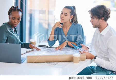 Architects, designers and engineers working together as a team on construction plans and blueprints while using laptop in creative office. Planning and design while discussing our vision for project 122758488