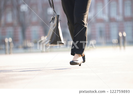 The feet of a young woman running through an office district 122759893