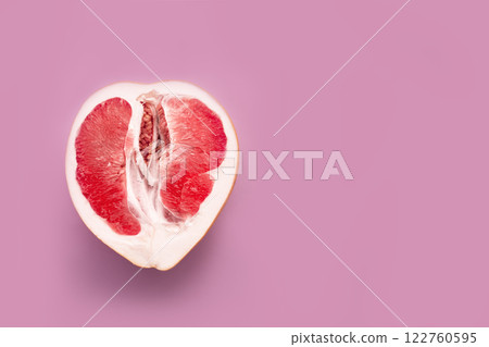 A half peeled grapefruit on a pink colored background. Minimal still life A half peeled grapefruit on a pink colored background. Minimal still life 122760595