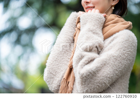A smiling Japanese woman wearing a scarf in the park 122760910