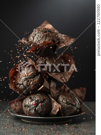 Dark chocolate muffins on a black background. 122760980