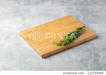 Cutting board and rosemary on a stone table. Cutting board and rosemary on a stone table. 122760999