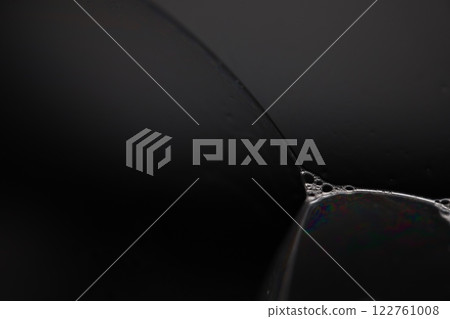 Transparent liquid surface, bubbles of thick liquid, silver reflection on dark background, gray colours, dark abstraction 122761008