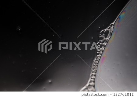 Transparent liquid surface, bubbles of thick liquid, silver reflection on dark background, gray colours, dark abstraction Transparent liquid surface, bubbles of thick liquid, silver reflection on dark background, gray colours, dark abstraction 122761011